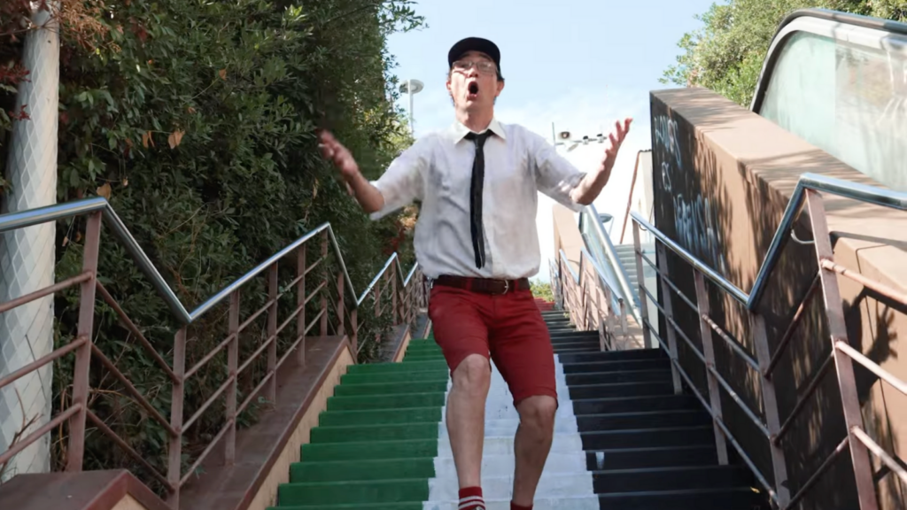Cantante de Las Manos de Filippi en primer plano descendiendo una escalera pintada con la bandera palestina durante el videoclip Palestina